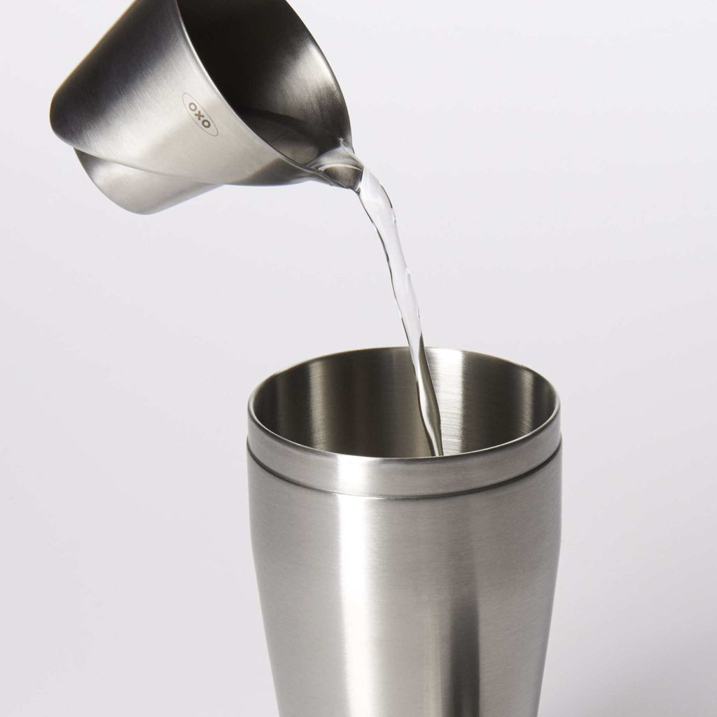 Pouring liquid from angled stainless steel jigger