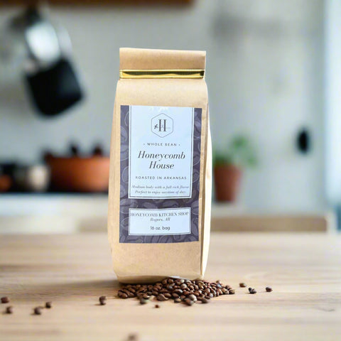 Bag of Honeycomb House whole bean coffee sitting on a kitchen counter with a few coffee beans on the counter. 