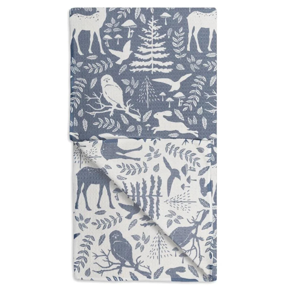 Folded fabric with nature-themed pattern featuring deer, birds, and trees on a blue background