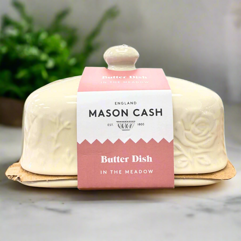 butter dish by mason cash on a kitchen countertop with a green plant in the background